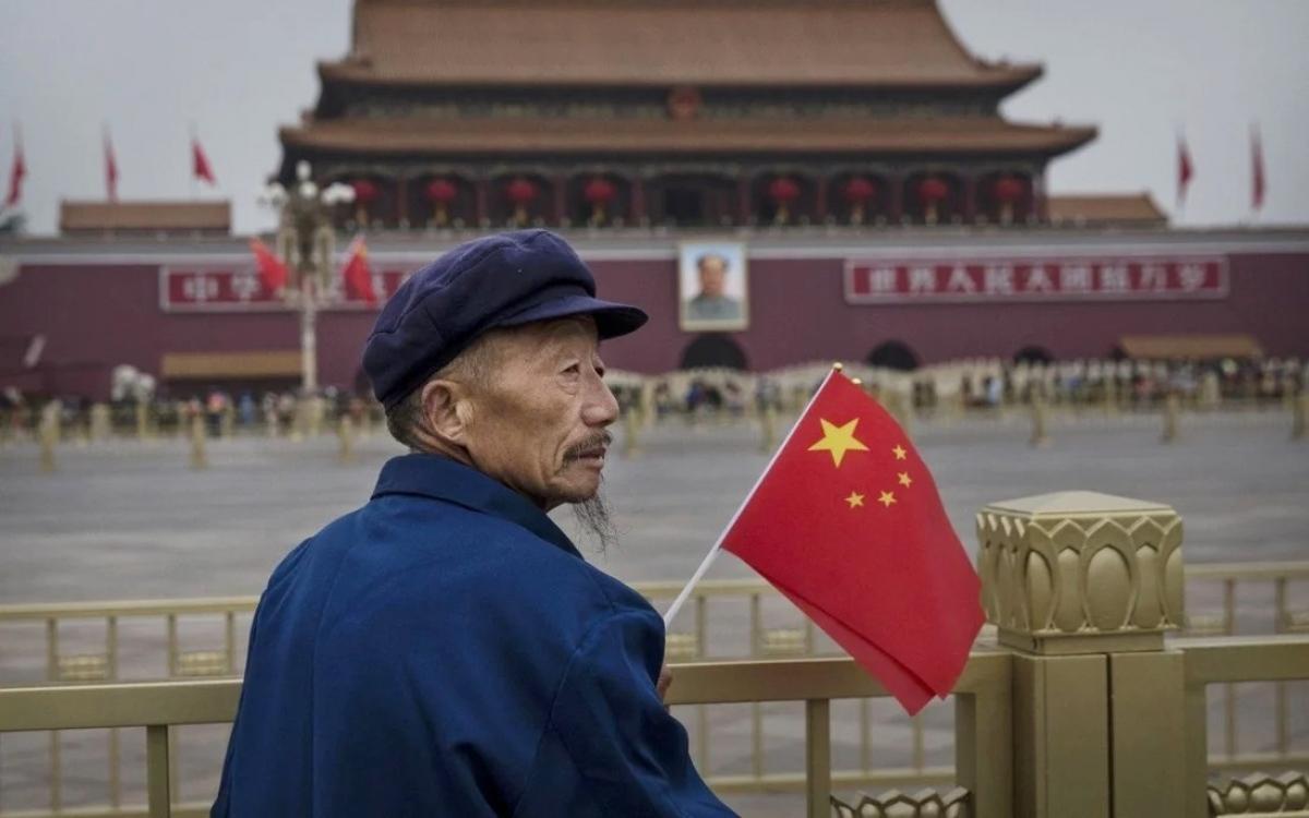 Một ông lão cầm quốc kỳ Trung Quốc ở khu vực quảng trường Thiên An Môn. Ảnh: Getty.