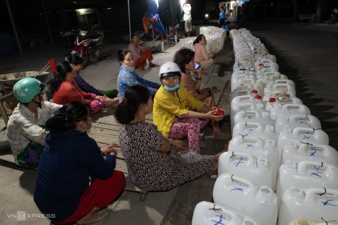 Người dân xã Tân Phước, huyện Gò Công Đông, Tiền Giang, thức   suốt đêm chờ lấy nước từ thiện trong mùa khô hạn kéo dài, tháng 4/2024. Ảnh: Thanh Tùng