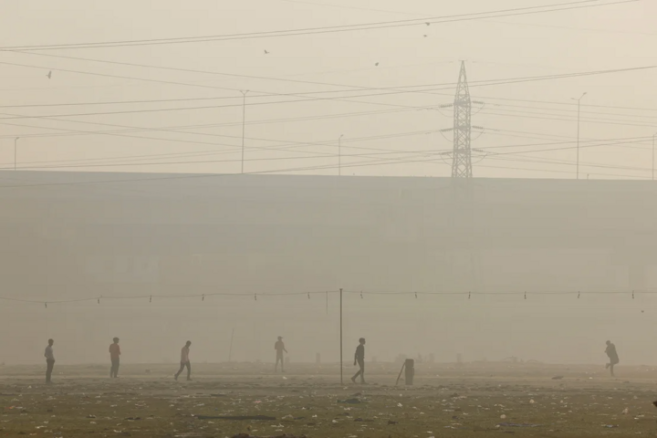 Những người đàn ông chơi cricket trong khi bầu trời bị bao phủ bởi khói bụi ở Delhi, ngày 20/11. (Ảnh: Reuters)